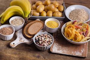 a table with potatoes, bananas, pasta, beans, oats, farro, and lentils