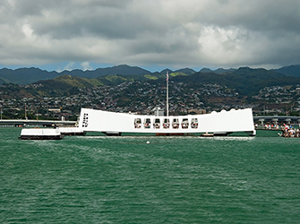 a white rectangular building that is surrounded by ocean water