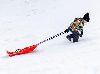 a child pulling a sled up a hill