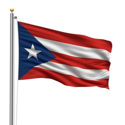A flag with 5 red and white horizontal stripes. There is a blue triangle on the left. On the triangle, there is one large white star.