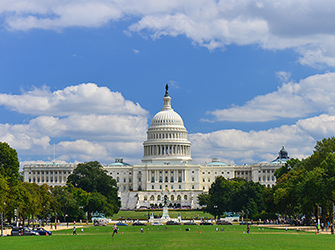 A long white building with a white dome on top.