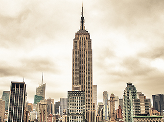 There is a very tall building with an antenna on top. The building is much taller than the other buildings around it.