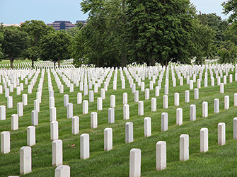 There are many rows of white tombstones next to each other.