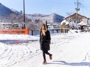 A woman walking outside in the snow.