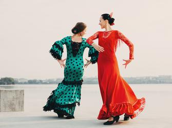 two flamenco dancers move in a circle around each other